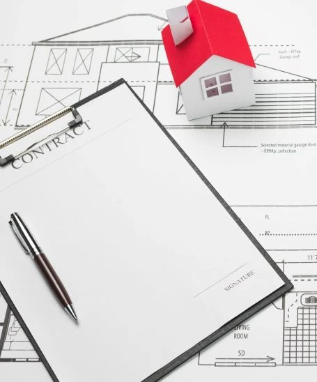 cellphone-and-clipboard-with-small-house-model-on-blueprint.jpg